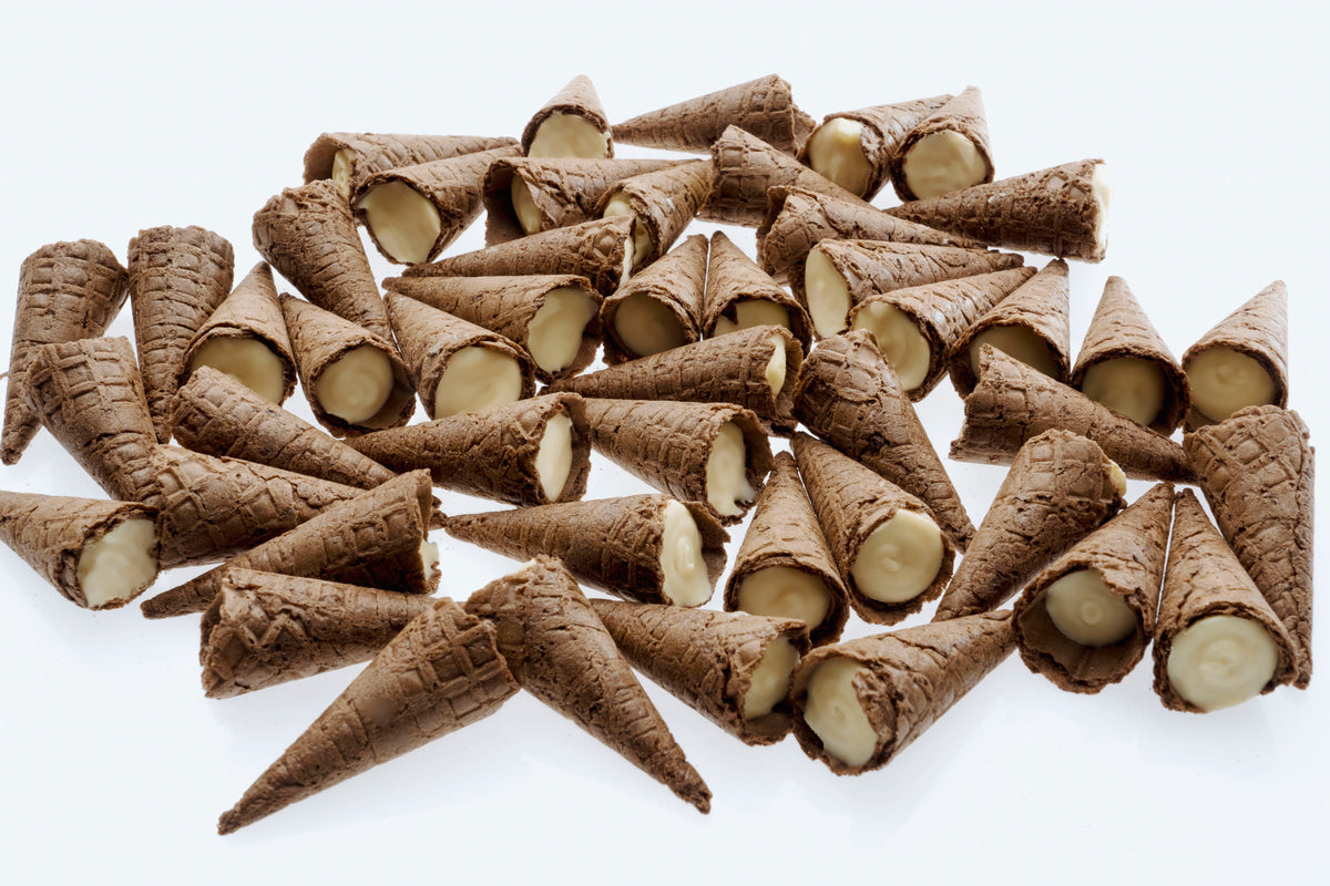 Loose White Choc Tippies tipped out of the pouch — waffle cone tips with a white chocolate flavoured filling